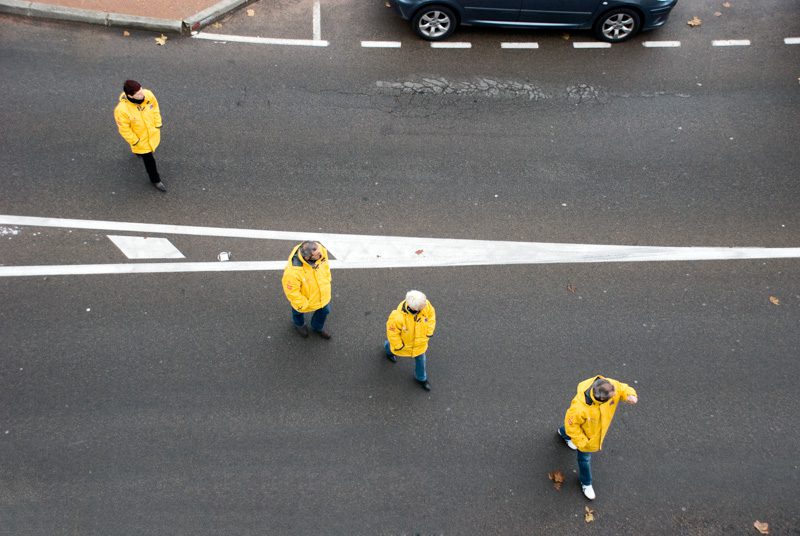 Le point de vue en photographie-plongée-4 personnages en ciré jaune traversant la route