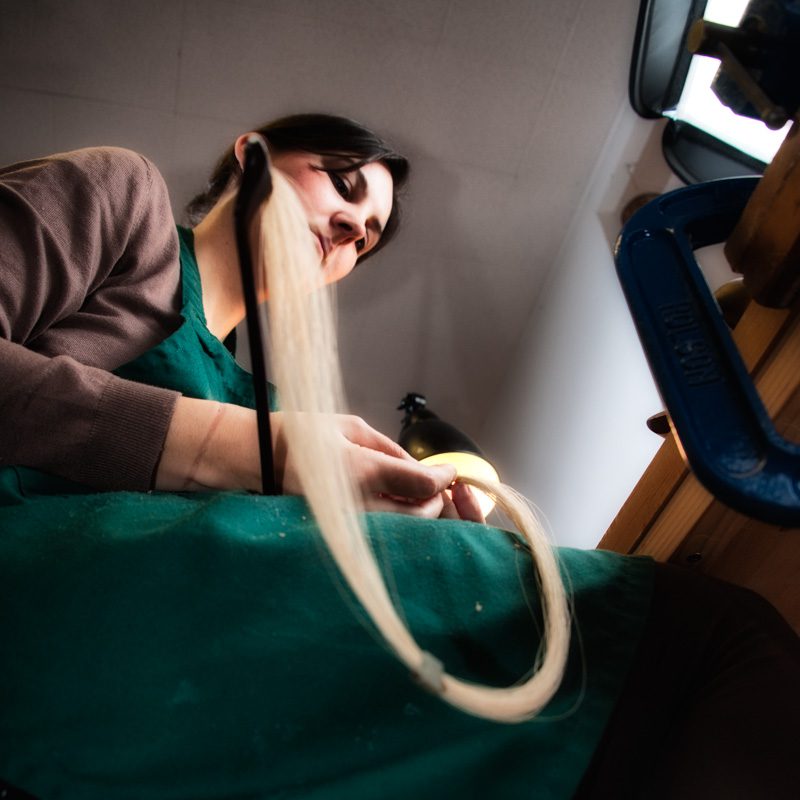 Le point de vue en photographie-contre-plongée-luthière réparant un archet