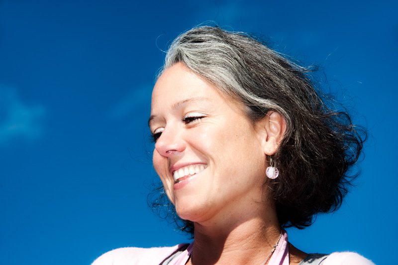 Le point de vue en photographie-contre-plongée-portrait de femme souriant sur fond de ciel bleu