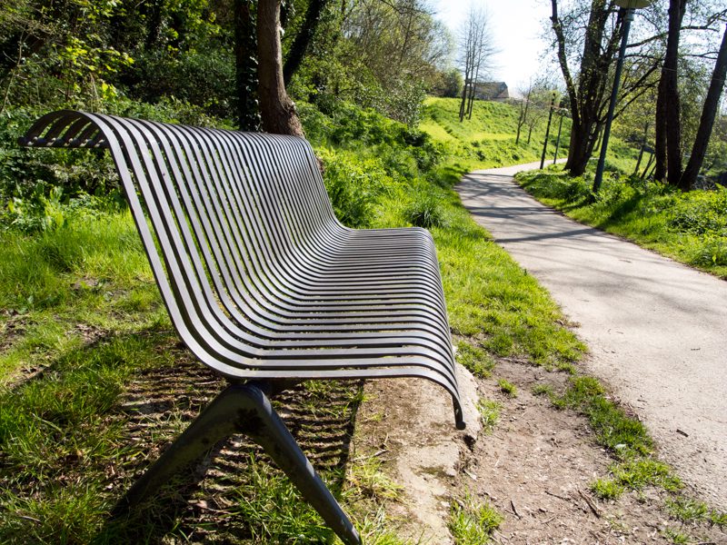 Le point de vue en photographie-Banc en métal vu de côté avec allée
